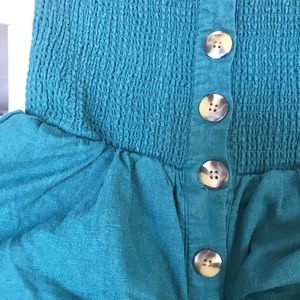 Sleeveless turquoise jumper.